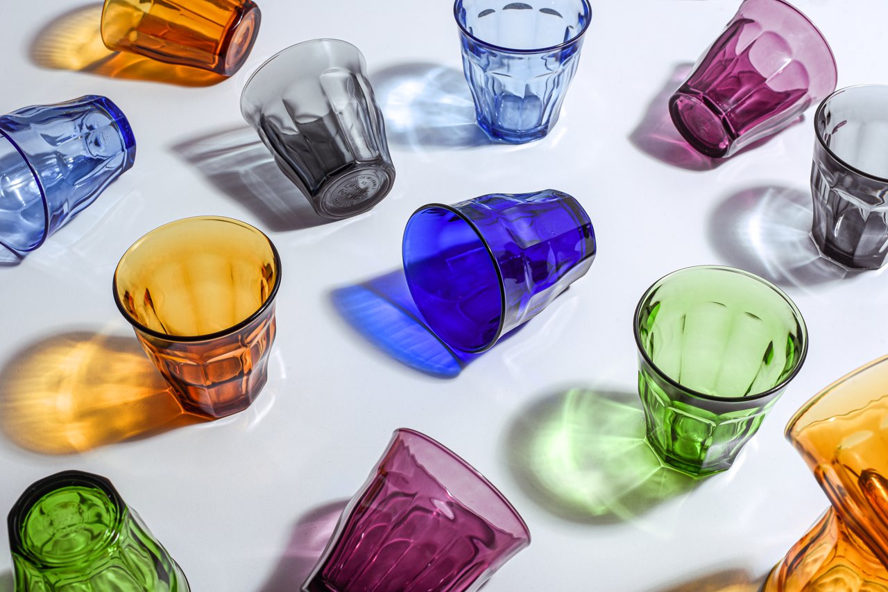 Des verres Picardie Duralex de plusieurs couleurs sur une surface blanche