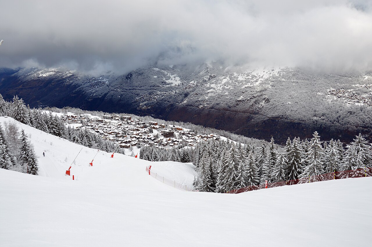 Une piste de ski enneigée surplombe le village de Courchevel Le Praz