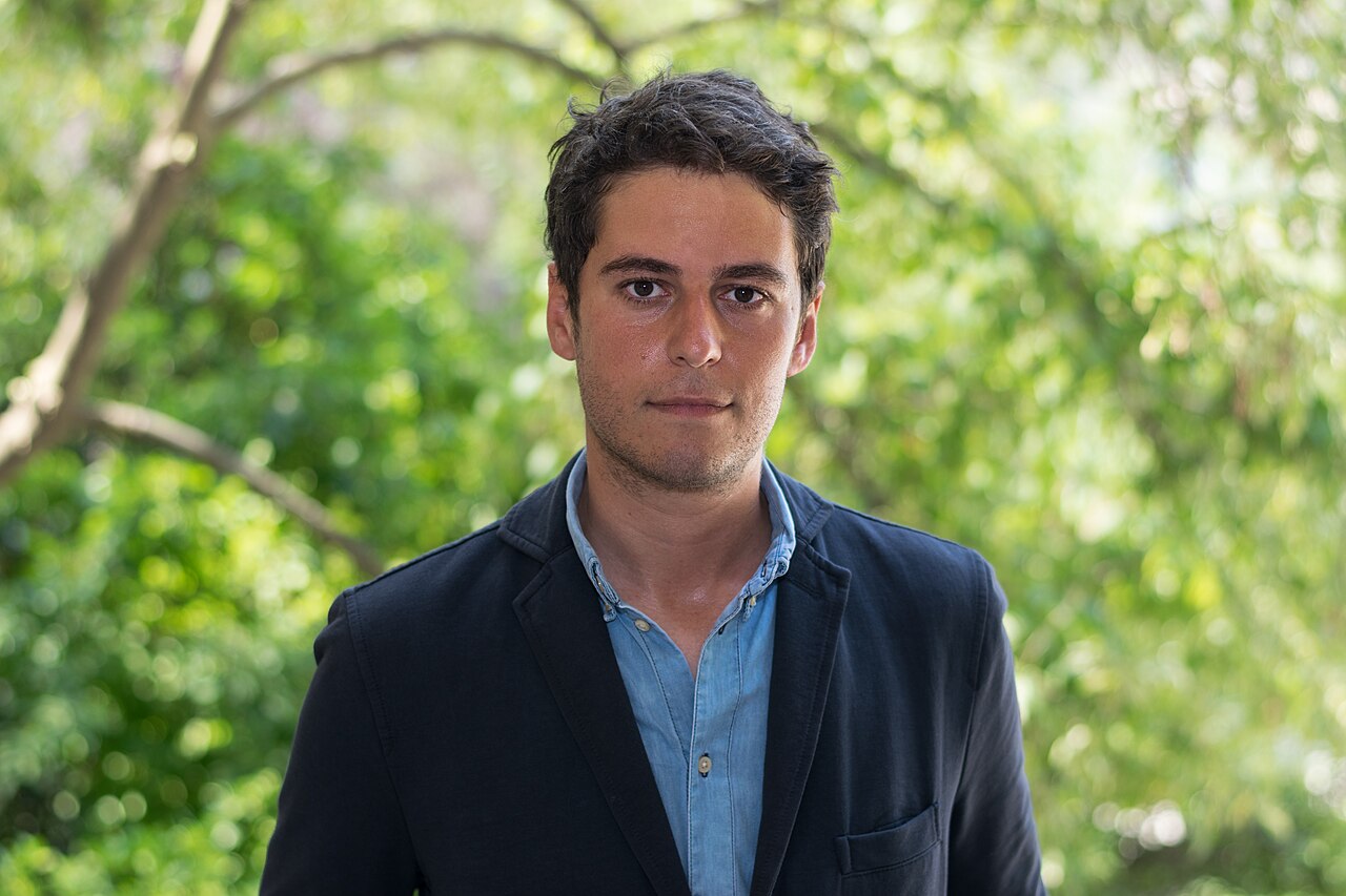 Gabriel Attal, en veste sombre, photographié devant des arbres au Palais Bourbon