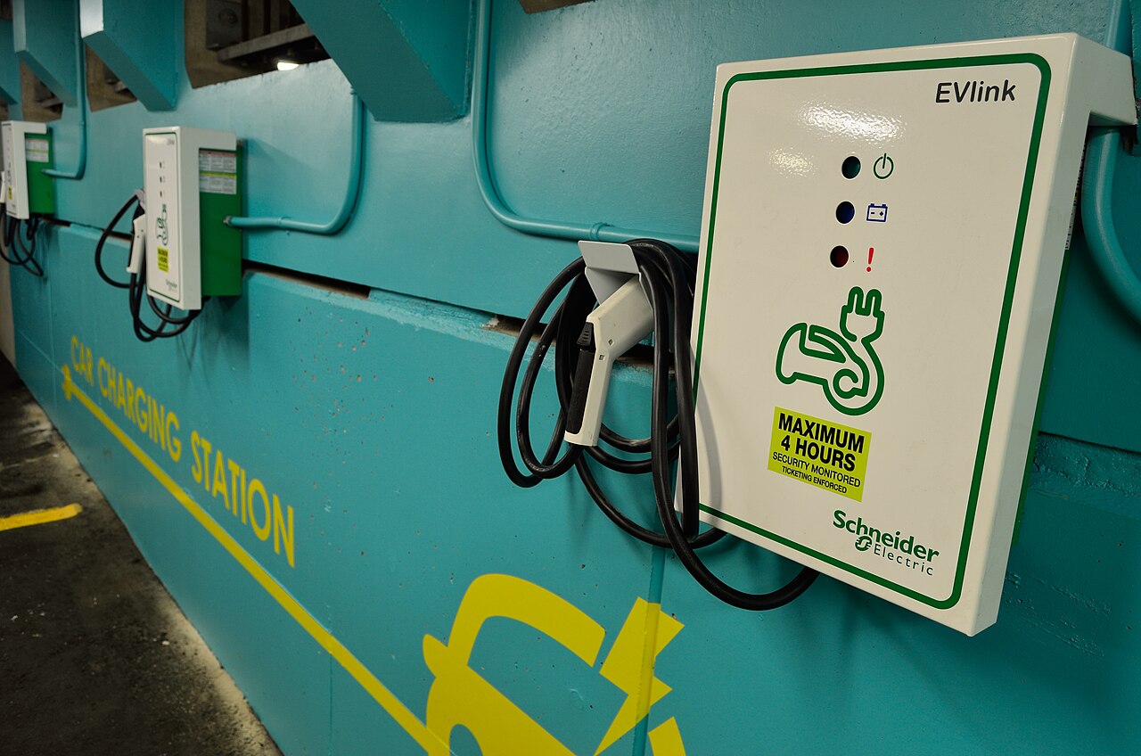 Des bornes de recharge EVlink de Schneider Electric fixées à un mur turquoise