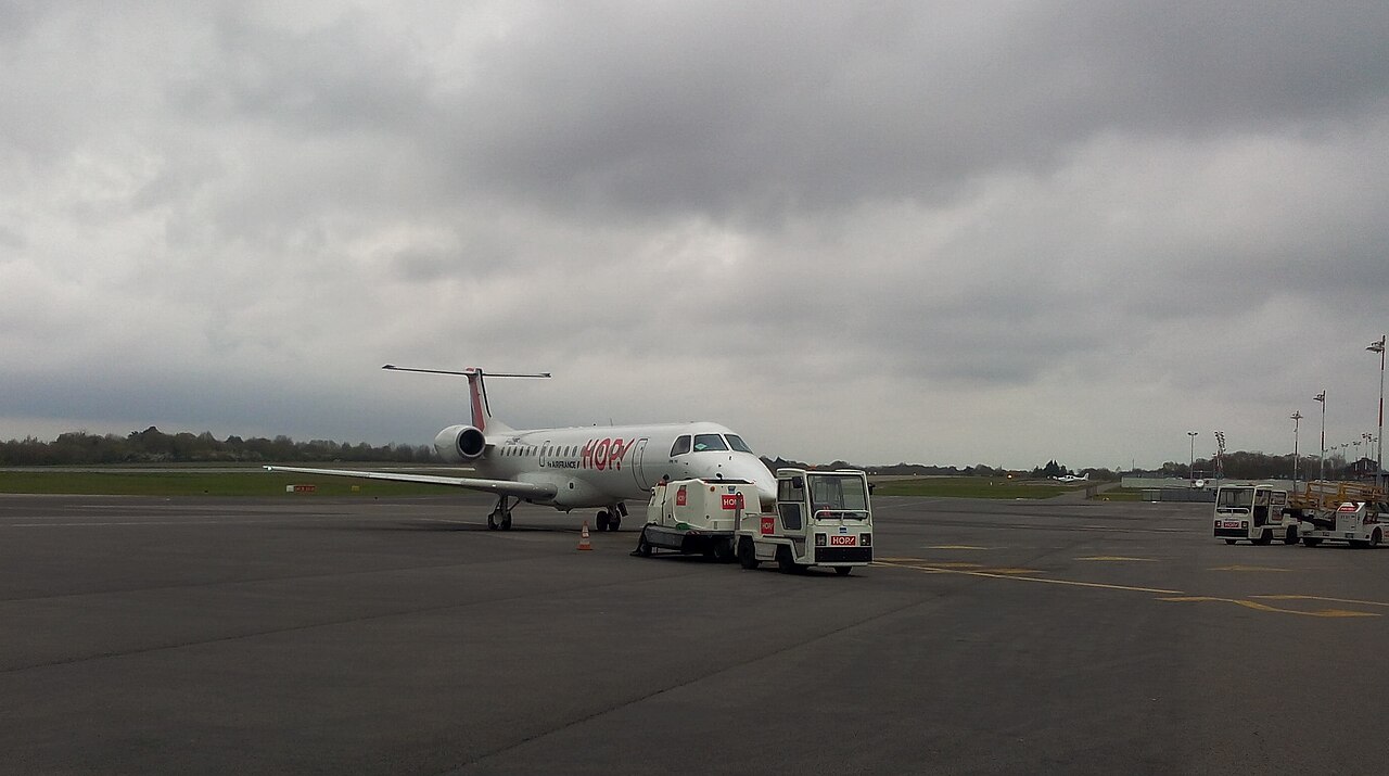 Un Embraer ERJ 145 de Hop ! stationné sur le tarmac de Nantes Atlantique, près de véhicules de service
