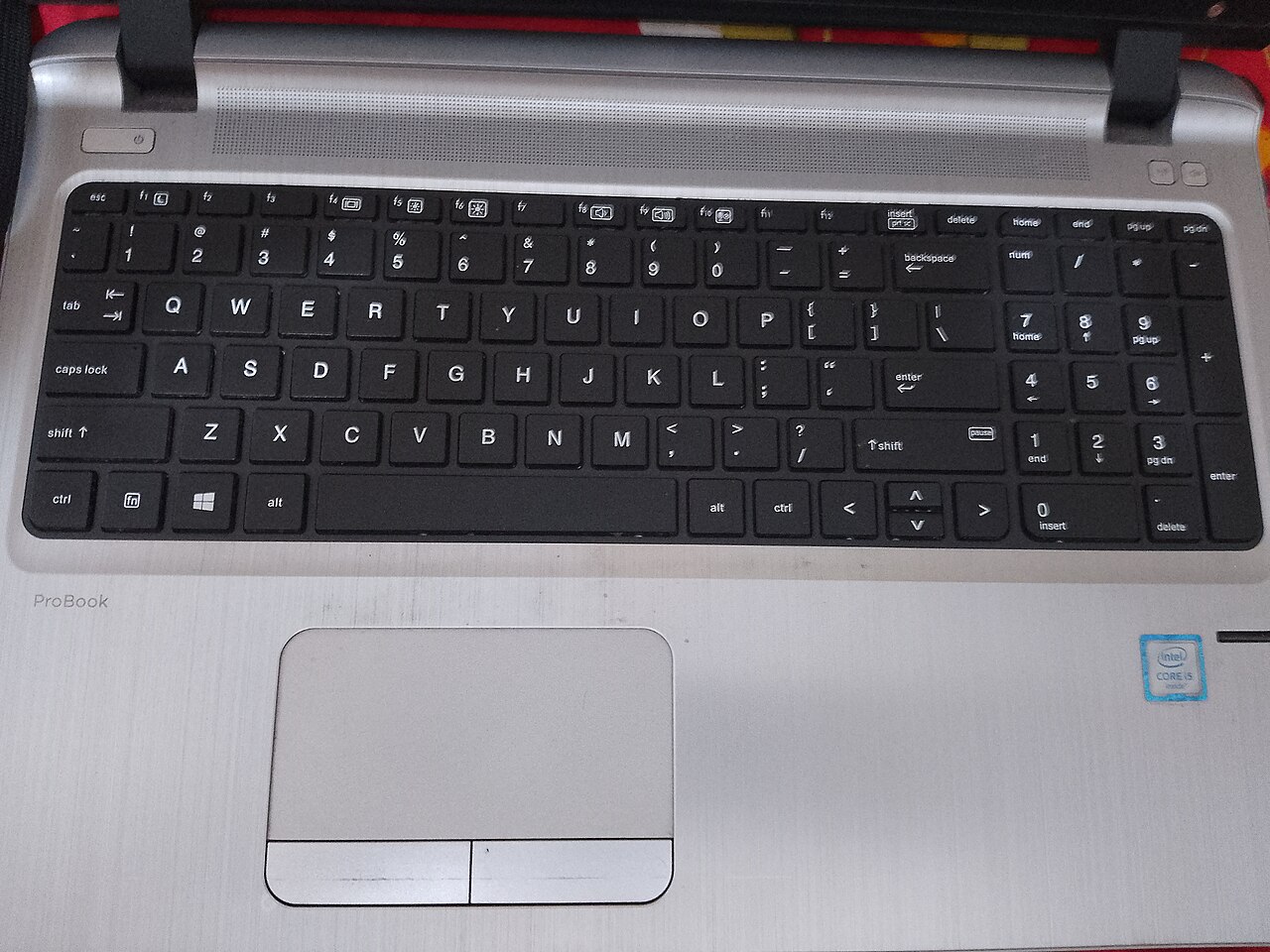 Le clavier noir et le pavé tactile gris d’un ordinateur portable.