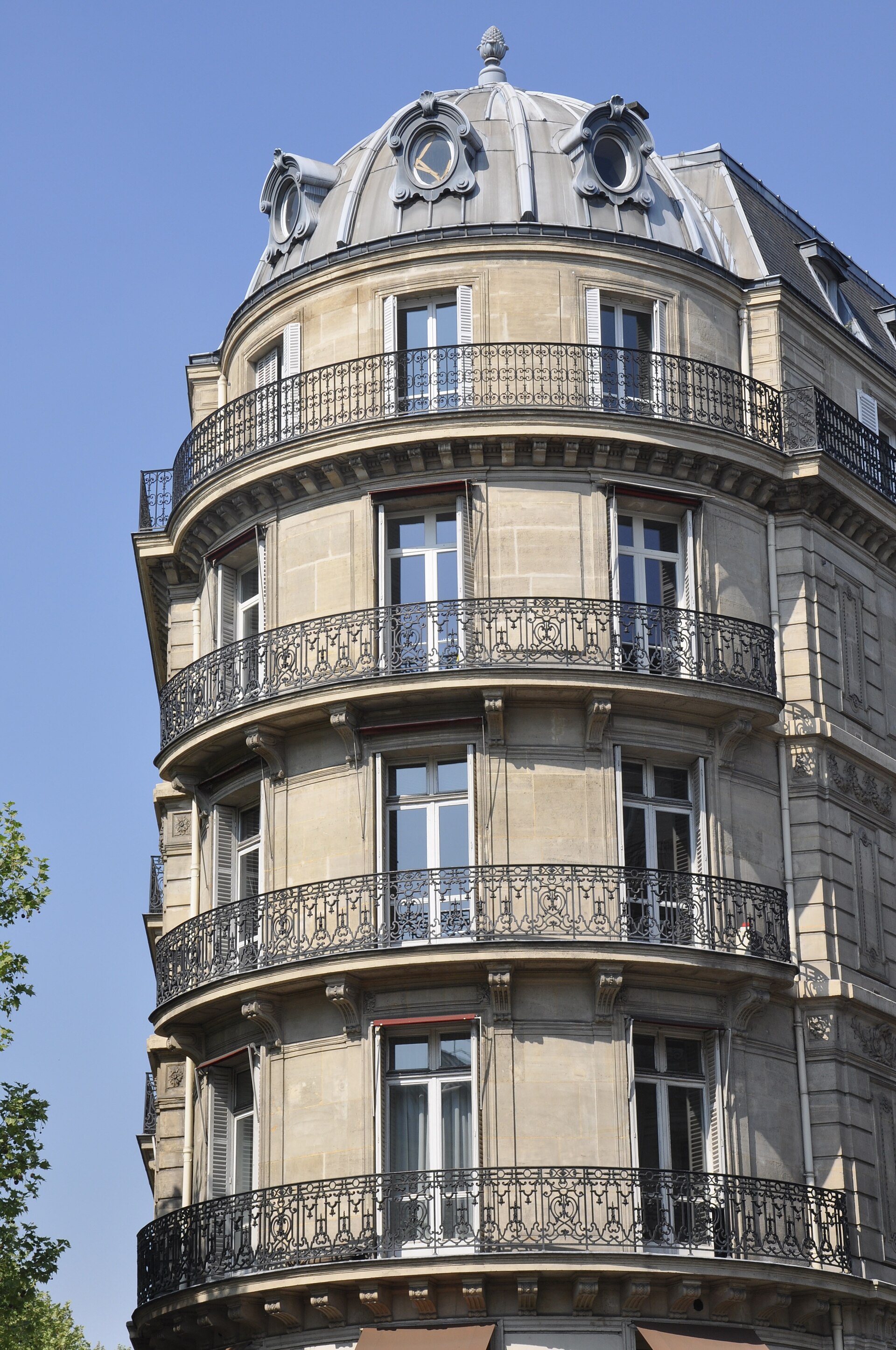 Des balcons et fenêtres sur la façade d’un immeuble parisien.