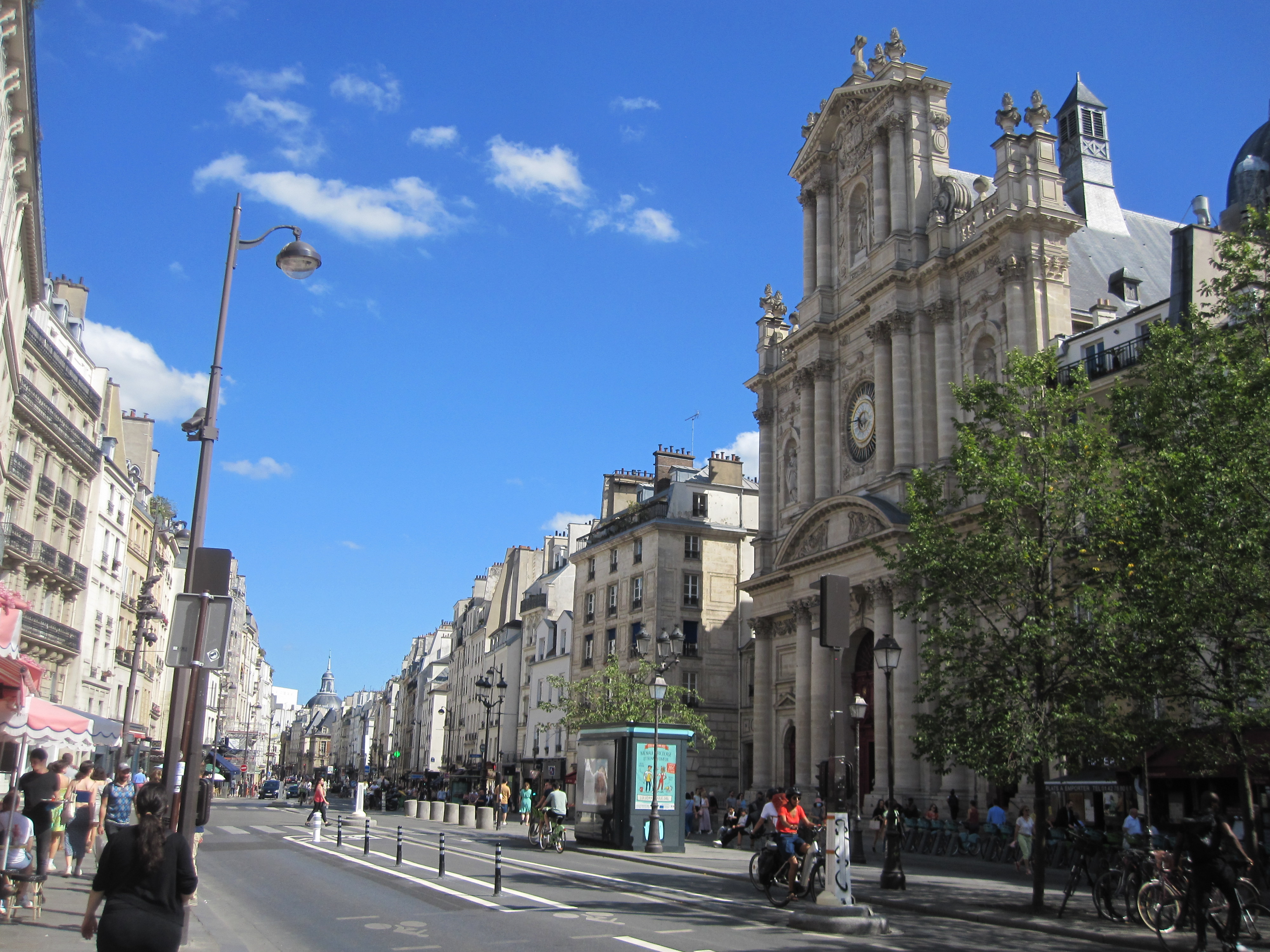 Une rue du centre de Paris bordée d’immeubles et d’une église ancienne